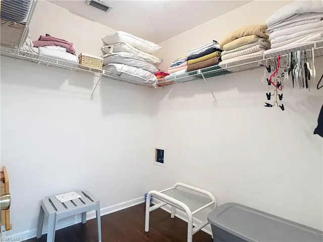 The property includes a spacious storage area with white walls and dark flooring, featuring extensive wire shelving installed at a high level