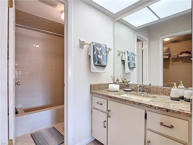The bathroom features a vanity with a granite countertop and a built-in sink