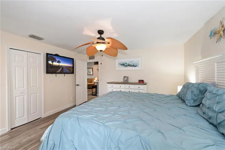 Bedroom with ceiling fan, light wood-style floors, and a closet