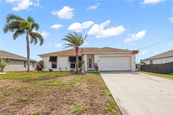 Single story home featuring an attached garage, stucco siding, and driveway