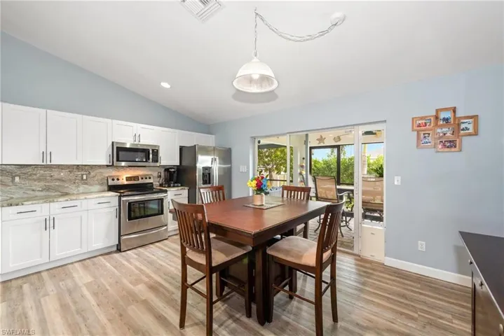 Dining space with vaulted ceiling, light wood-type flooring, and recessed lighting