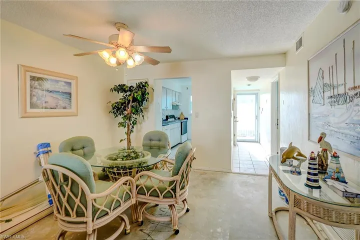 Dining area with a textured ceiling, concrete floors, and a ceiling fan