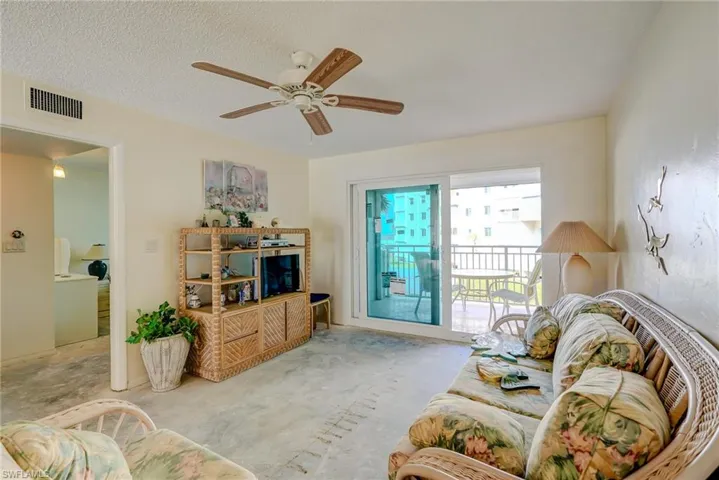 Living room with ceiling fan and a textured ceiling
