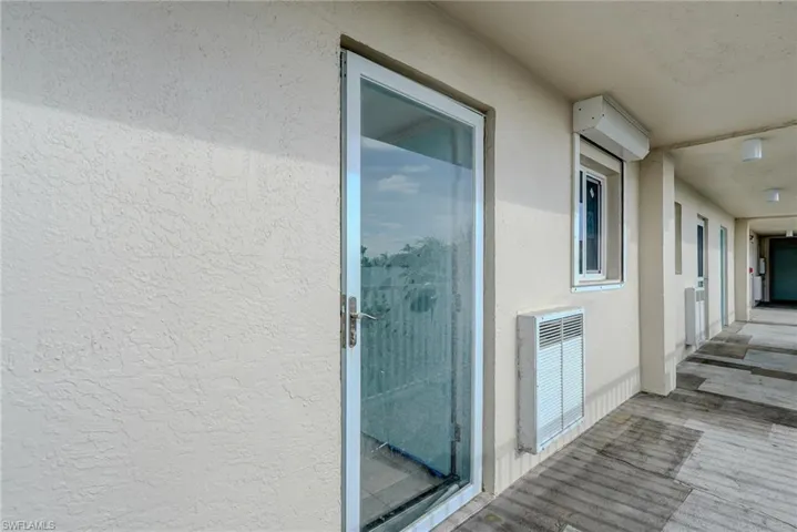 View of exterior entry featuring stucco siding and heating unit