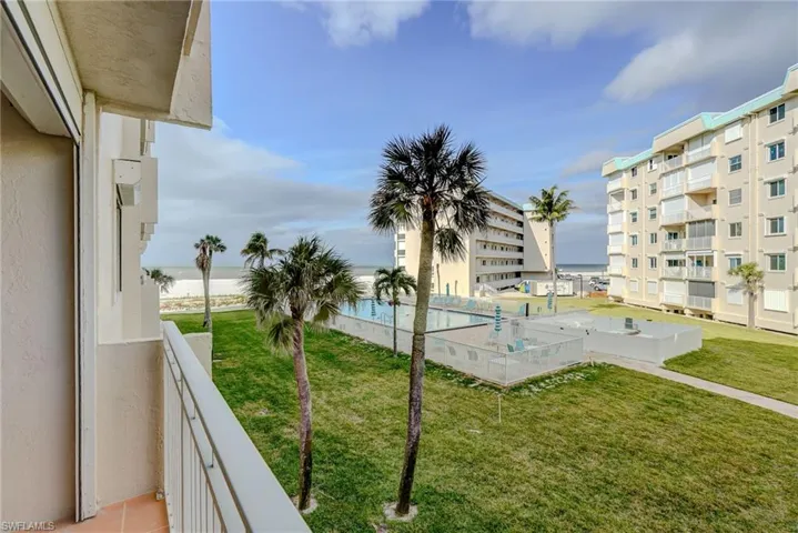 Balcony featuring view of water and beach