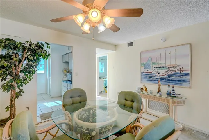 Dining area with a textured ceiling and a ceiling fan
