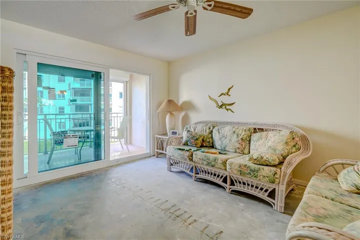 Sitting room featuring a textured ceiling, a ceiling fan, and unfinished concrete floors