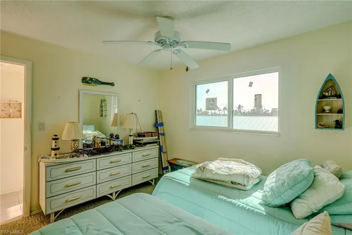 Bedroom featuring a ceiling fan, a textured ceiling, and tile patterned floors