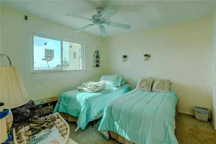 Carpeted bedroom featuring a ceiling fan and baseboards