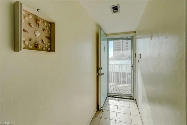 Doorway to outside featuring tile patterned flooring and baseboards