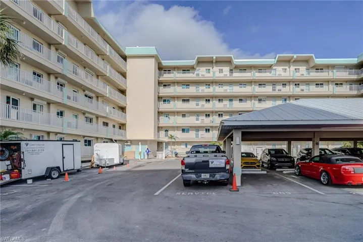 View of apartment building / complex with uncovered parking