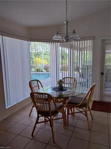 Dining space with light tile patterned floors and a chandelier