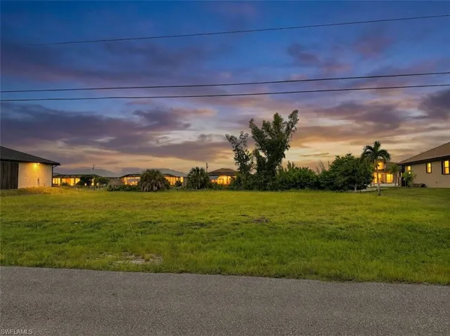 Expansive green space featuring natural vegetation and surrounding structures