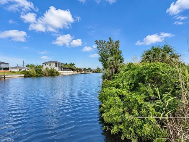 Waterfront property with established landscaping and a paved seawall