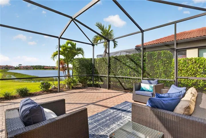 Screened-in lanai featuring paver flooring, metal frame enclosure, and water frontage