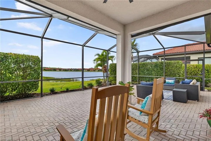 Screened-in lanai featuring brick paver flooring, a covered ceiling, and water frontage