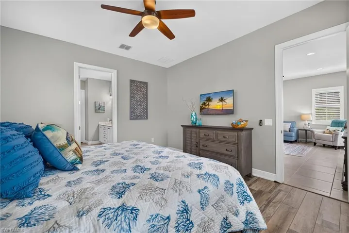 Bedroom featuring wood-finish flooring, a central ceiling fan with integrated lighting, and neutral wall paint