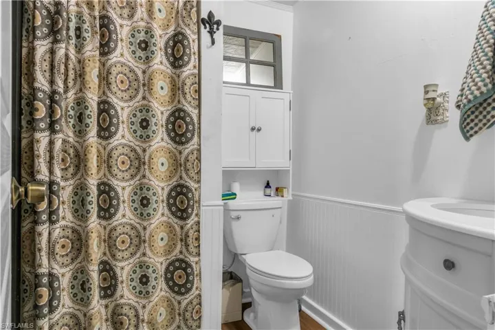 First Floor Bathroom featuring shower, ornamental molding, vanity, and toilet