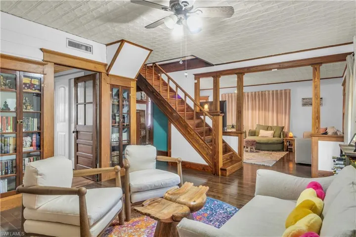 Living room with hardwood floor, built in cabinets and ceiling fan