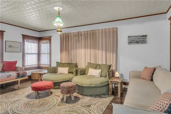 Living room featuring ornamental molding and wood flooring