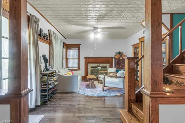 Living room with a wealth of natural light, ceiling fan, and hardwood flooring