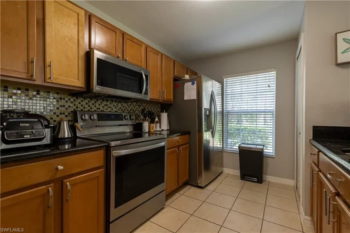 Living area featuring a ceiling fan and light tile patterned flooring