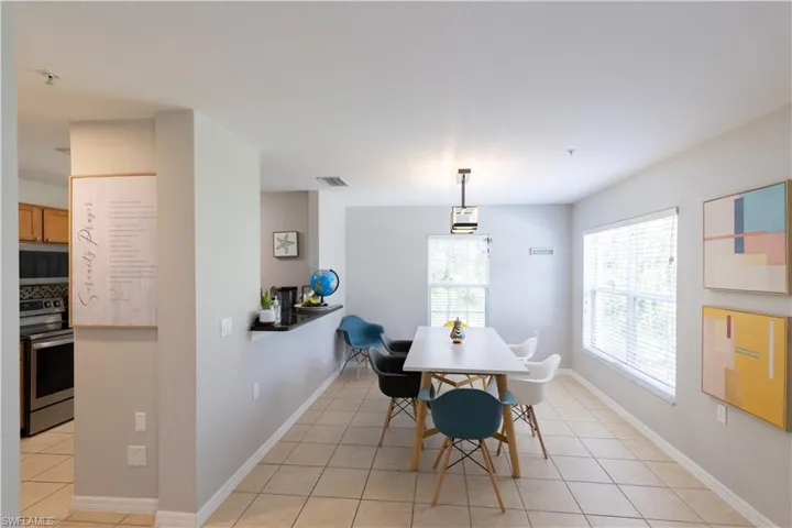 Laundry room featuring stacked washer and dryer and light tile patterned flooring