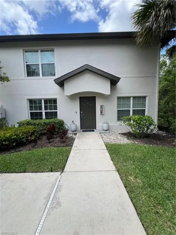 View of front facade featuring stucco siding and a front yard