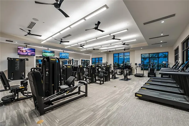 Exercise room with ceiling fan and carpet