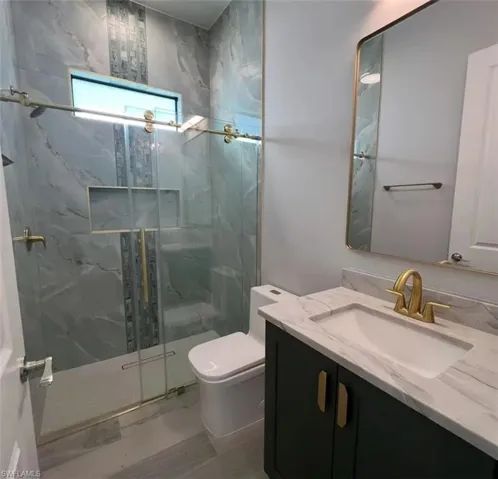Full bath with vanity and a marble finish shower