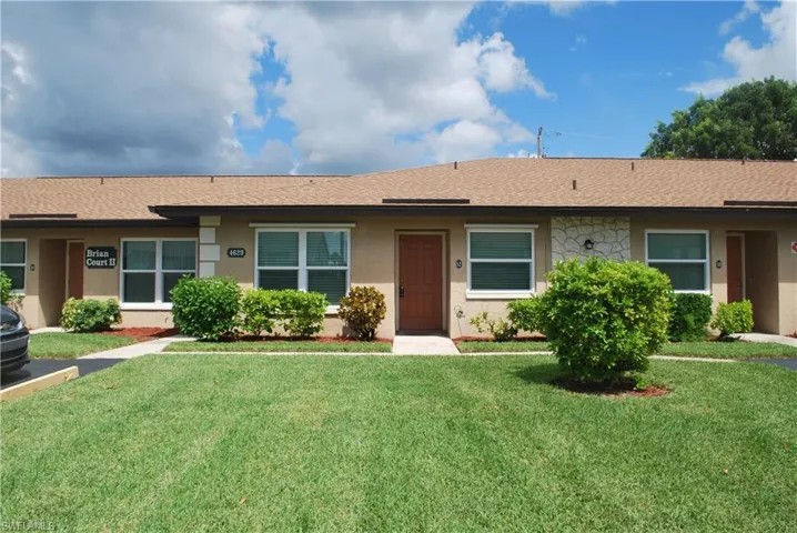 Single story home featuring a front yard, a shingled roof, and stucco siding