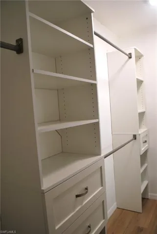 Primary Walk in closet featuring wood finished floors