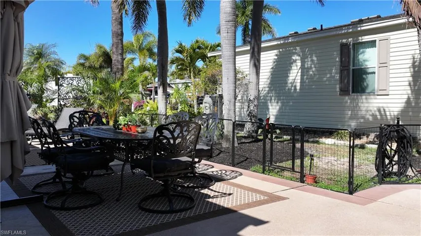 View of patio with outdoor dining space and a gate