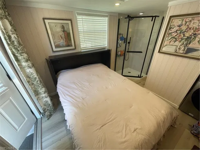 Bedroom with wood walls and light wood-style floors