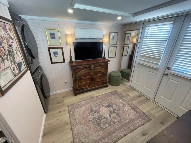 Entrance foyer with light wood-type flooring, crown molding, recessed lighting, and stacked washer / dryer