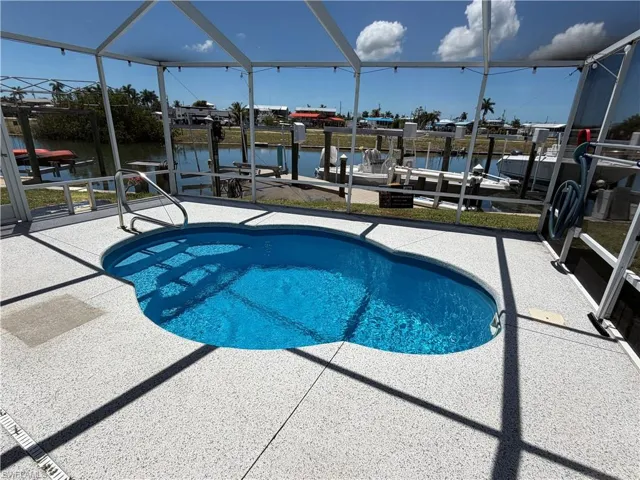 The property features a screened-in pool area with a clear blue pool and entertaining area