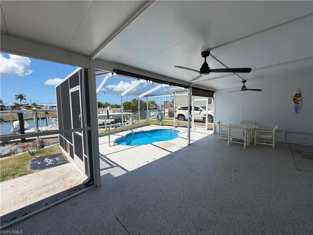 This property features a screened-in patio with a built-in pool, views of the canal