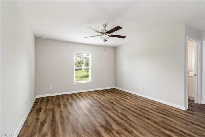 Unfurnished room featuring dark hardwood / wood-style flooring and ceiling fan