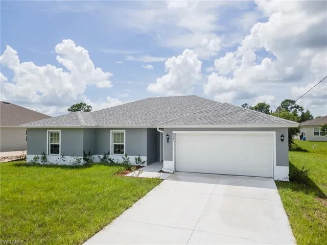 Single story home with a front yard and a garage
