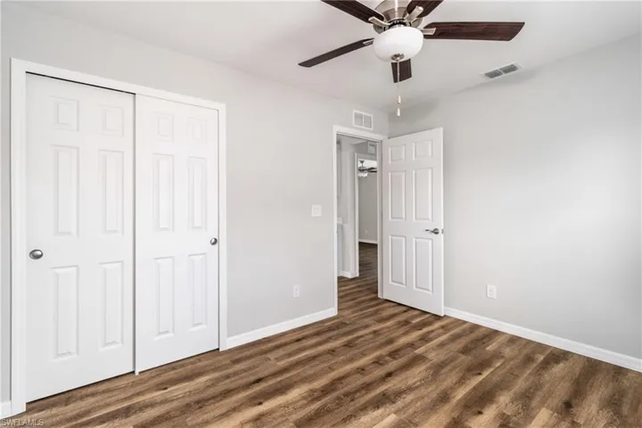 Unfurnished bedroom featuring a closet, ceiling fan, and dark wood-type flooring