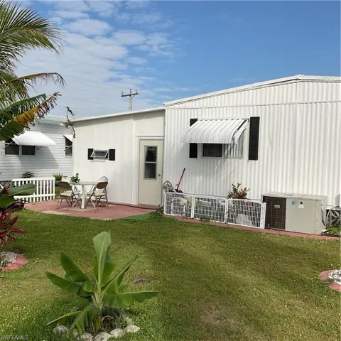 Rear view of property with a yard, central AC, and a patio