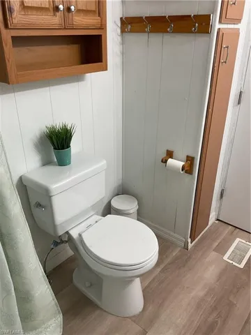 Bathroom with hardwood / wood-style floors and toilet