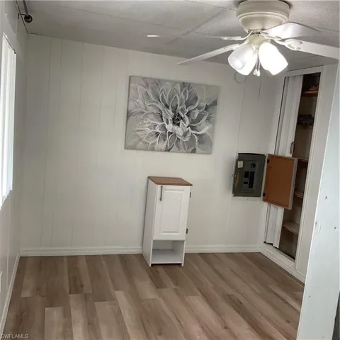 Spare room featuring ceiling fan, electric panel, and light hardwood / wood-style flooring