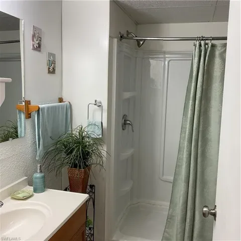 Bathroom featuring vanity, a textured ceiling, and walk in shower