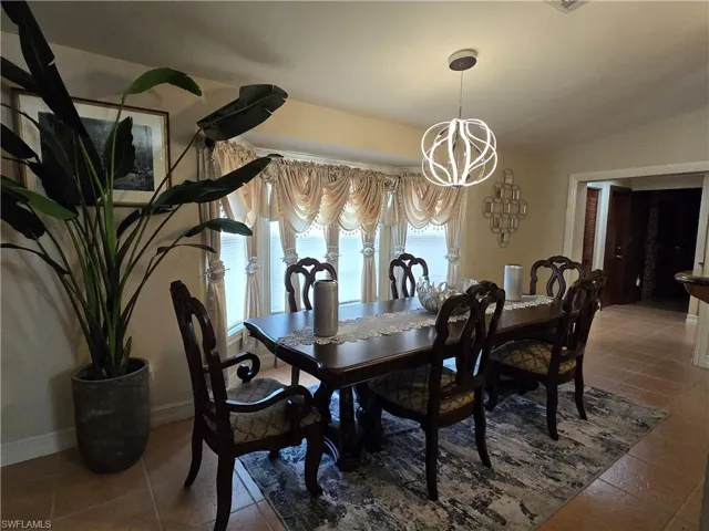 Dining area with an inviting chandelier and tile flooring