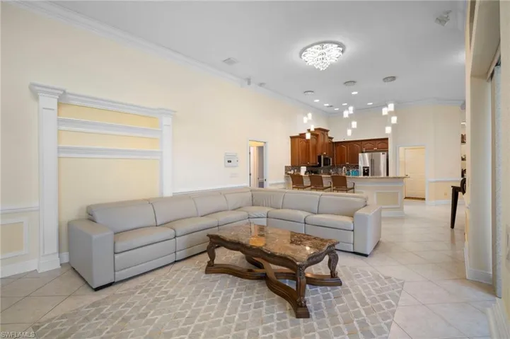 Living area with light tile patterned floors and crown molding