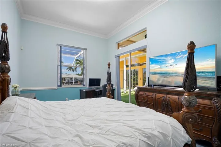 Bedroom with crown molding and access to outside