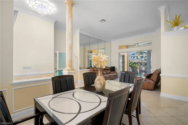 Dining room featuring ornamental molding, light tile patterned floors, and ornate columns