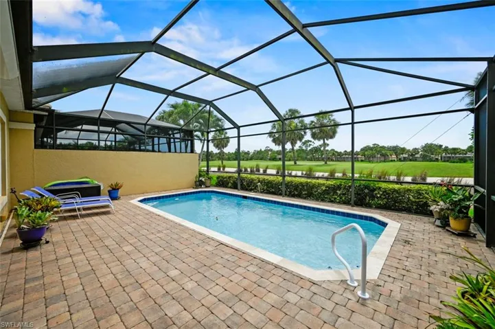Swimming pool with a patio area, view of golf course, and a lanai