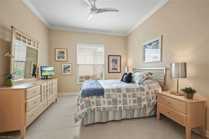 Bedroom featuring ornamental molding, light tile patterned flooring, and ceiling fan